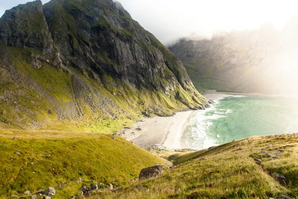 A quiet coast beneath steep green mountains
