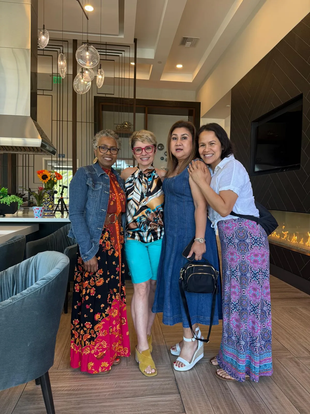 Mehri standing arm in arm with three guests in the gathering space