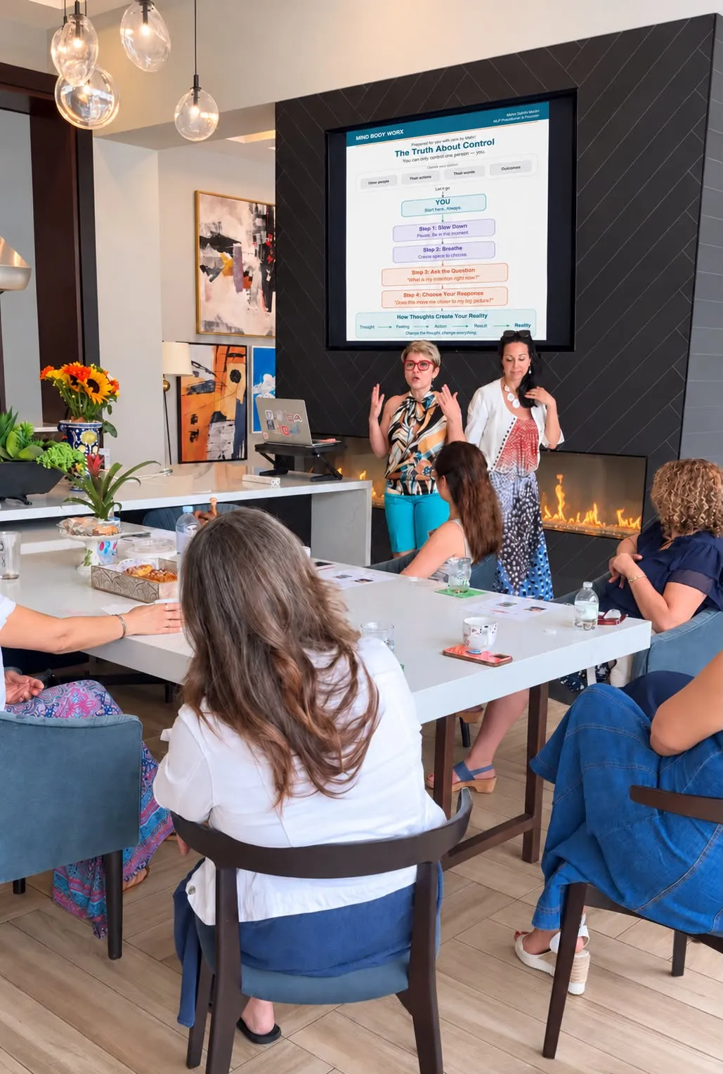Mehri presenting a slide titled The Truth About Control while guests listen around the table